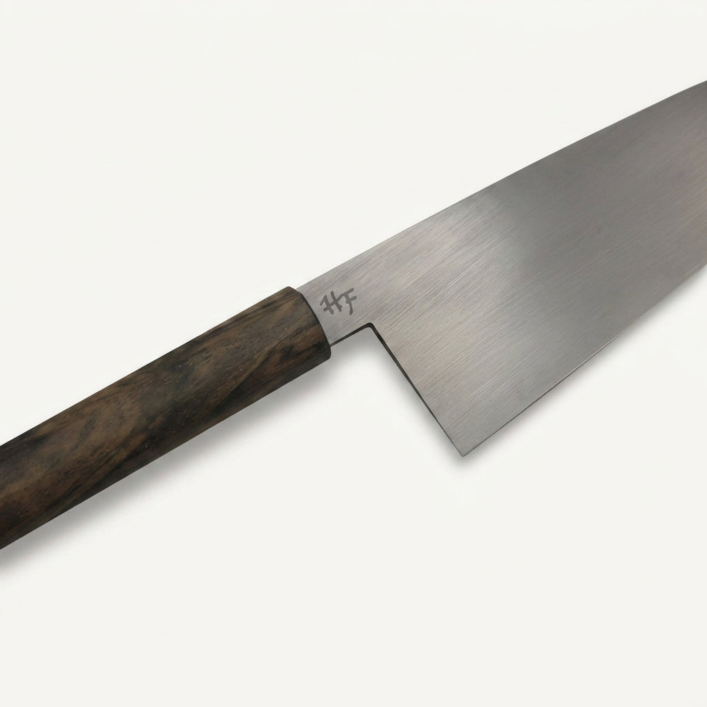 Close-up of the HandFab MK-III chef knife blade showing the 80CRV2 carbon steel heel and HF maker's mark